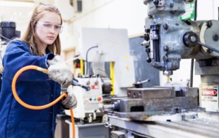 Female in Manufacturing Workplace with Air Hose