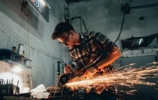 Welder working on piece with sparks flying