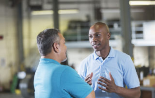 Two workers talking in a workshop