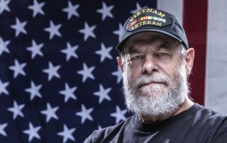 Veteran standing in front of American flag